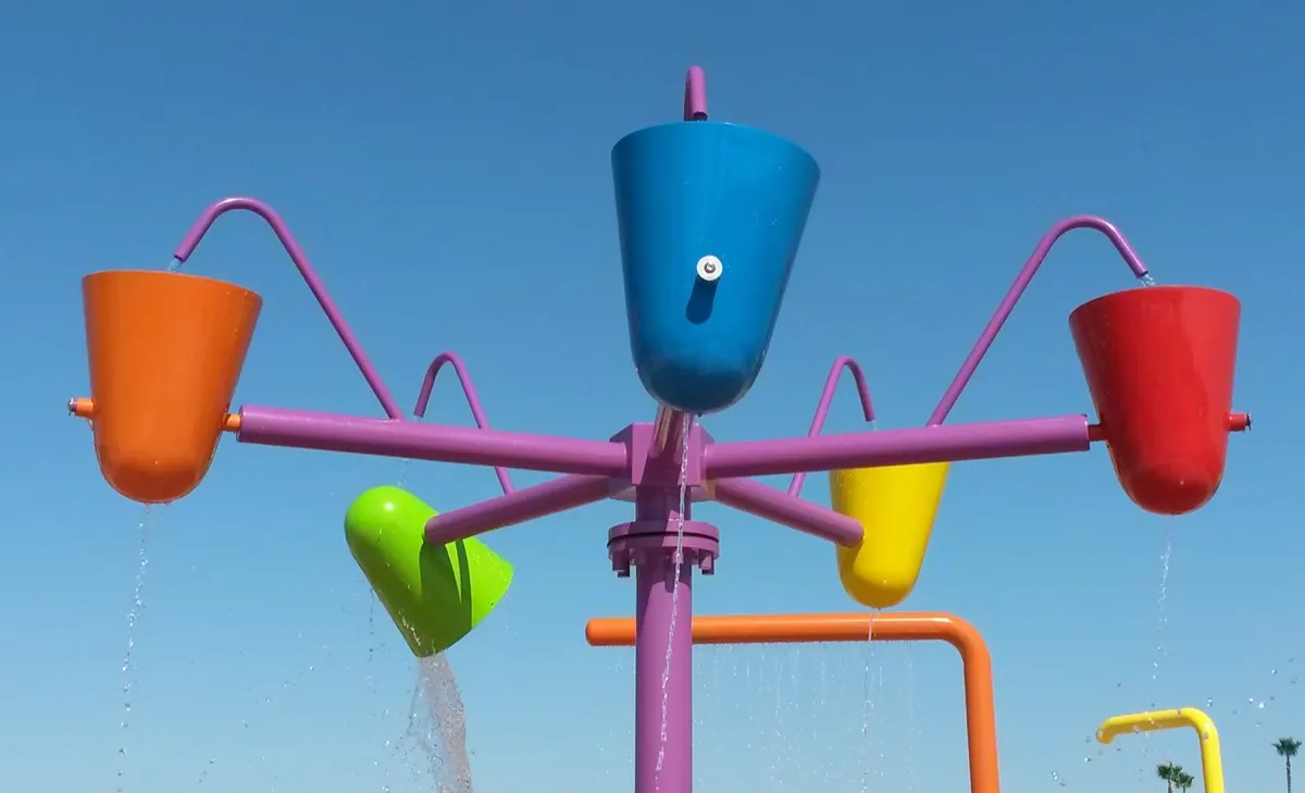 Multi-bucket dumping feature with colorful buckets against a blue sky
