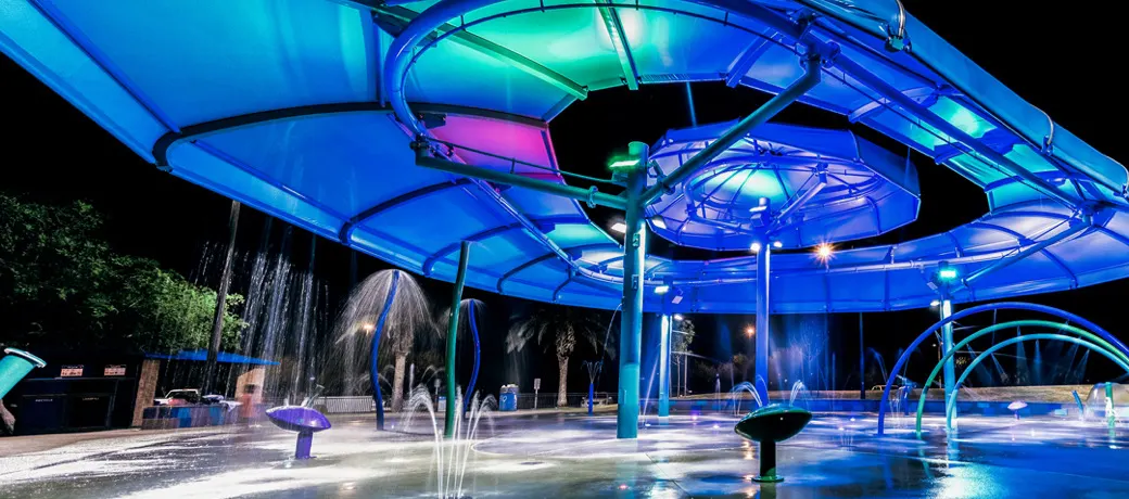 Splash pad lit with colored LED lights at night