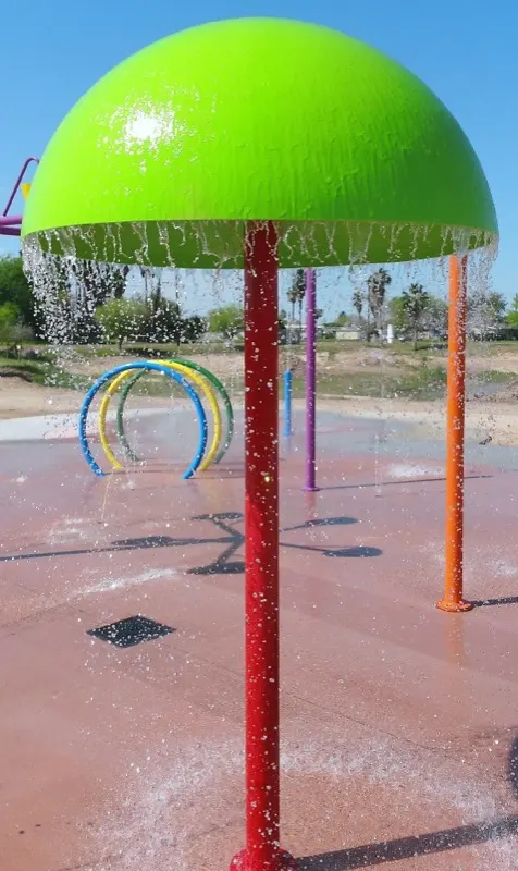 Green water mushroom splash pad feature with water falling from the canopy